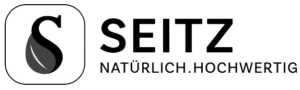 Logo von Seitz mit einem stilisierten schwarzen „S“ in einer grauen Tropfenform auf weißem Hintergrund, neben dem Markennamen in schwarzen Großbuchstaben und dem Slogan „natürlich.h